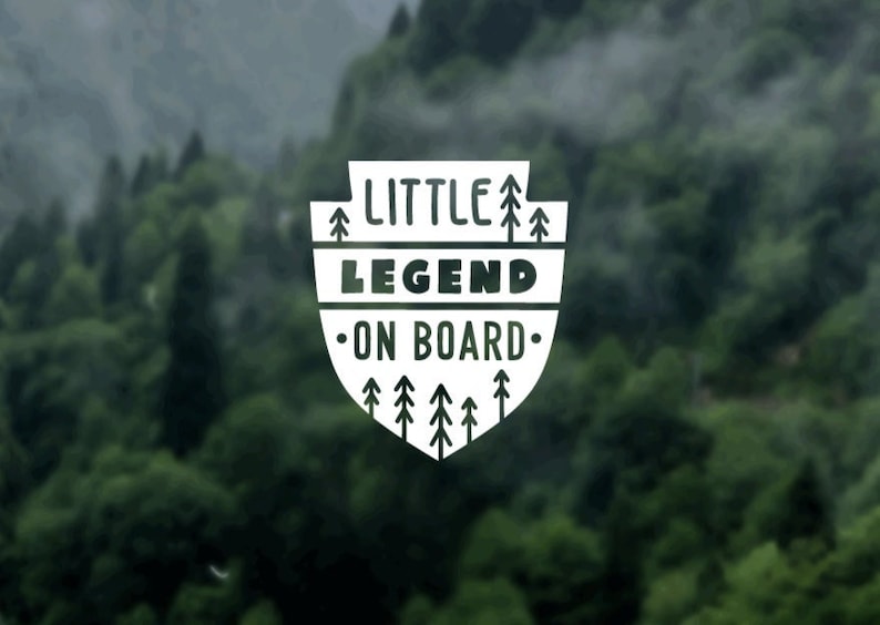 May include: White sticker with a shield shape and the text "LITTLE LEGEND ON BOARD" with stylized trees around the text.