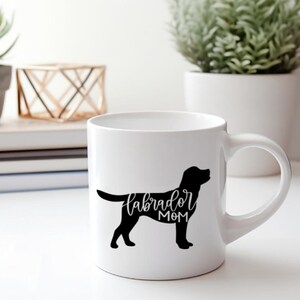 Pu&ograve; includere: Tazza in ceramica bianca con una silhouette nera di un labrador retriever e il testo "labrador mom" in scrittura nera.