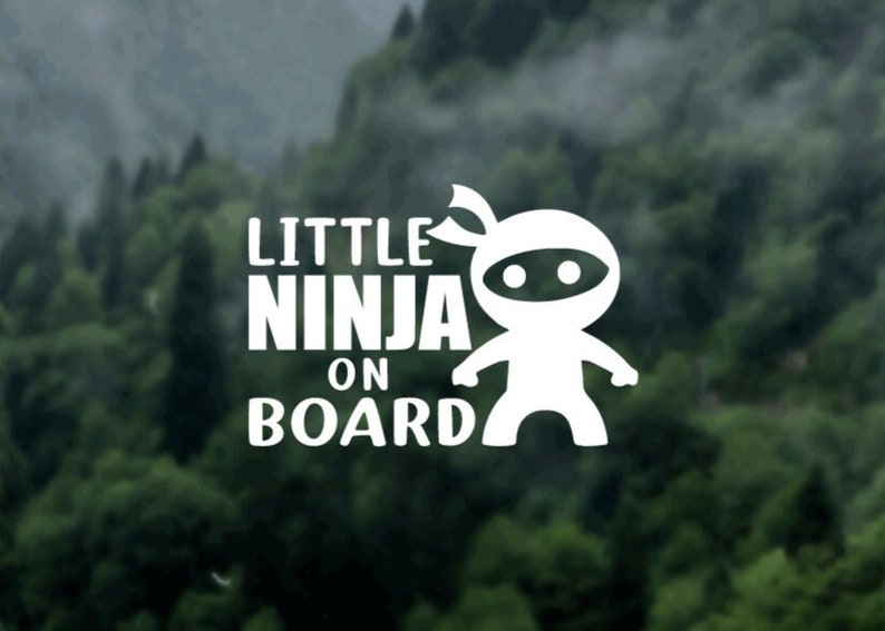 Puede incluir: Pegatina de vinilo blanco con un ninja de dibujos animados y el texto "Little Ninja On Board".