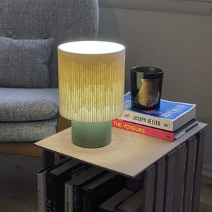 a lamp sitting on top of a table next to a stack of books