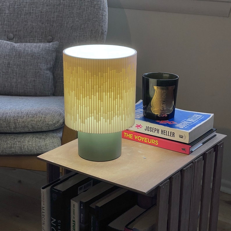 a lamp sitting on top of a table next to a stack of books