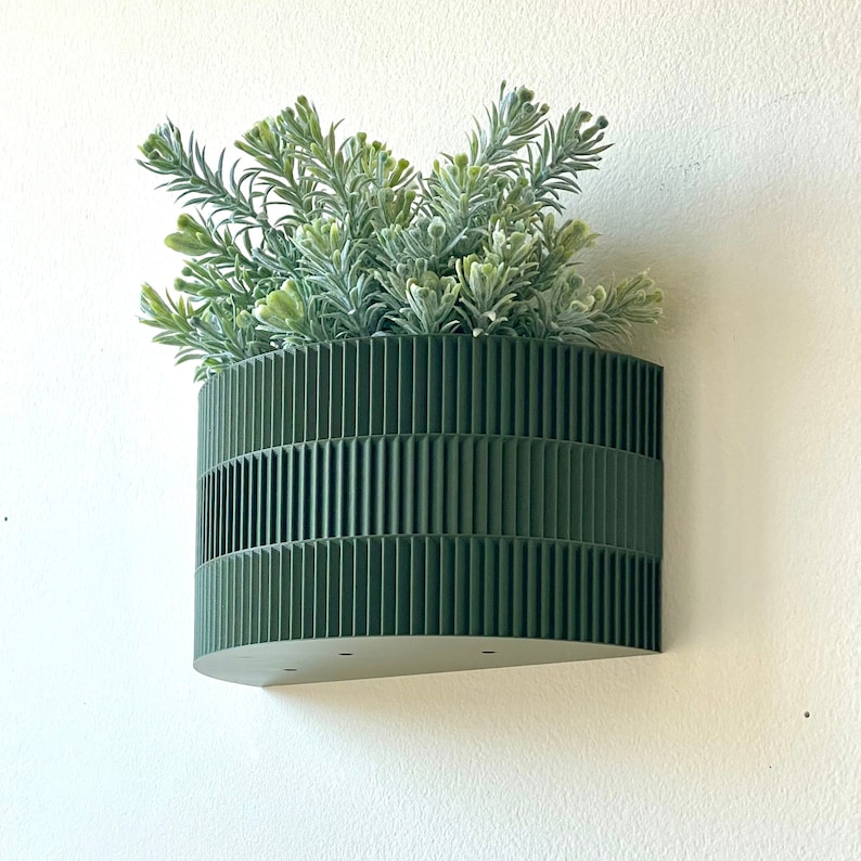 a green planter hanging from a wall