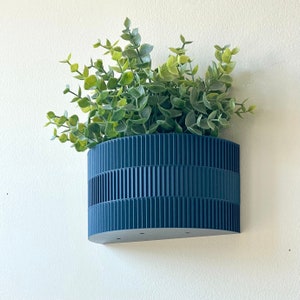 a blue planter hanging from a wall