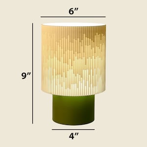 a green and white table lamp with measurements