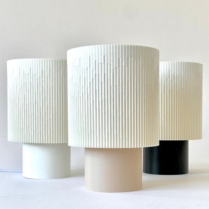 a couple of white lamps sitting on top of a table