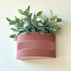 a pink planter hanging on a wall