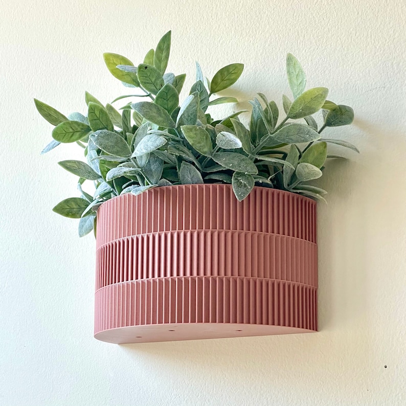 a pink planter hanging on a wall