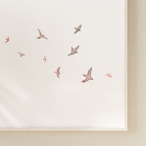 Puede incluir: Una pintura de acuarela de una bandada de p&aacute;jaros volando en un cielo blanco. Los p&aacute;jaros est&aacute;n pintados en tonos de marr&oacute;n y rosa.