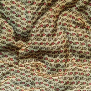Könnte beinhalten: Nahaufnahme eines Stoffes mit einem sich wiederholenden Muster aus kleinen, stilisierten Hasenformen. Die Hasen sind hauptsächlich rot und grau, vor einem hellbeigen Hintergrund. Der Stoff ist drapiert und erzeugt weiche Falten und Schatten.