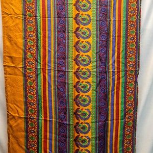 May include: A yellow, green, red, and purple striped fabric with a floral pattern.