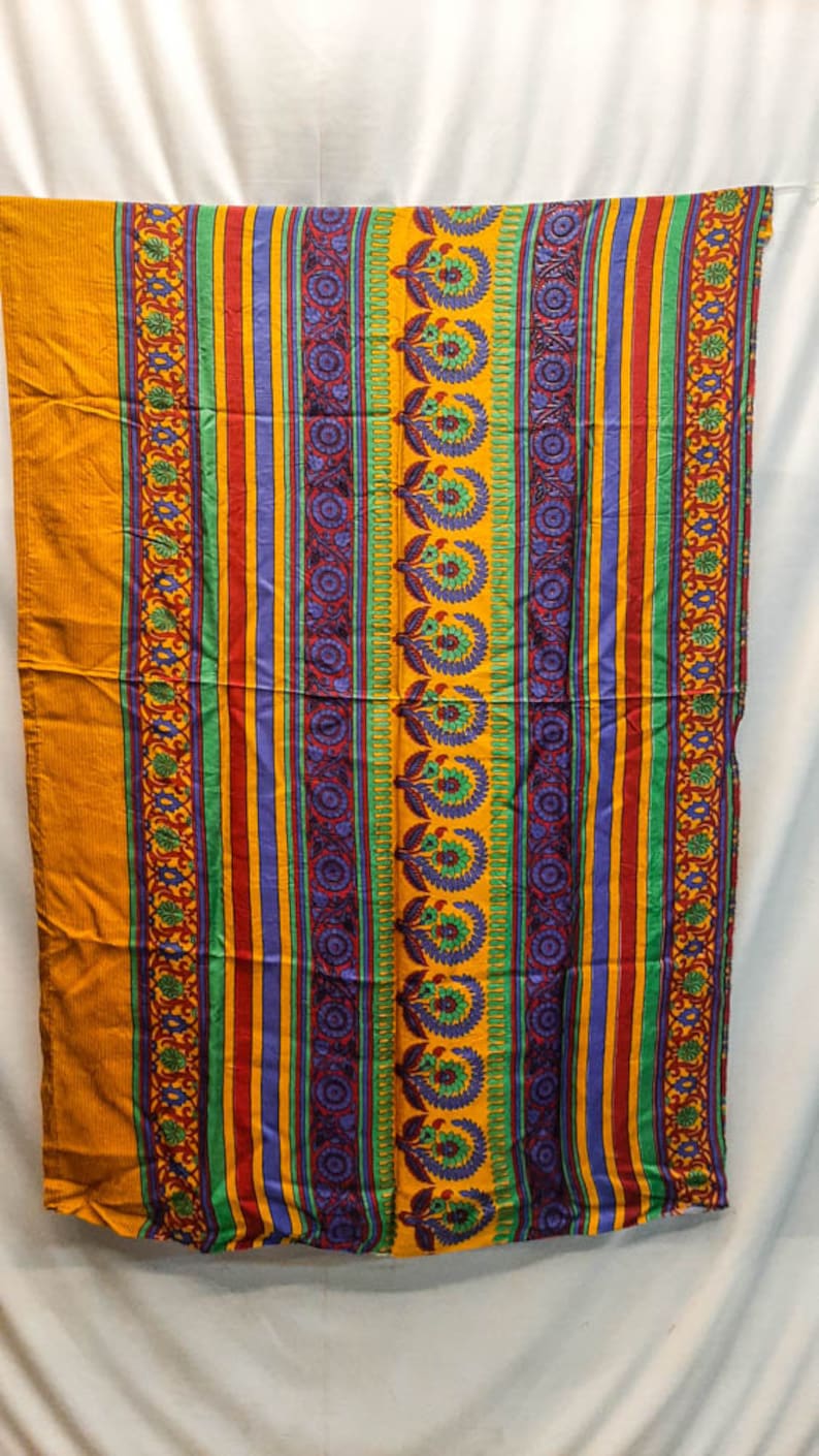 May include: A yellow, green, red, and purple striped fabric with a floral pattern.
