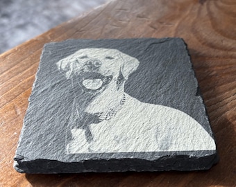 Könnte beinhalten: Ein schwarzer Schieferuntersetzer mit einem weißen, gravierten Bild eines Hundes. Der Hund ist ein Labrador Retriever mit herausgestreckter Zunge.