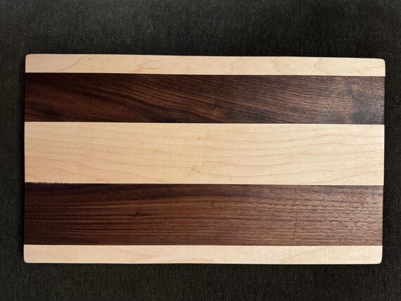 Dark walnut, maple, and ash laminated by a 17-year-old craftsman — the backstory alone makes this a genuinely personal, conversation-starting gift.