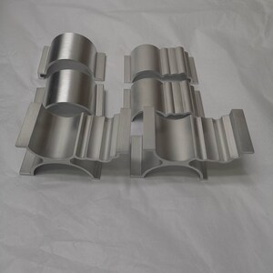 May include: Set of six silver metal brackets with a decorative design. The brackets are made of aluminium and have a smooth, polished finish.