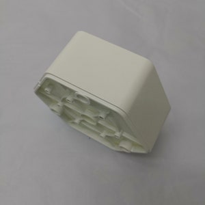 以下が含まれることがあります： 底に複数の小さな穴が開いた六角形の白いプラスチックボックス