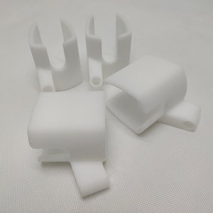 Peut inclure: Quatre pi&egrave;ces en plastique blanc imprim&eacute;es en 3D avec une ouverture en forme de U. Les pi&egrave;ces sont con&ccedil;ues pour &ecirc;tre utilis&eacute;es comme support ou support.