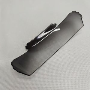 Puede incluir: Una visera para el sol de coche de plástico gris oscuro.