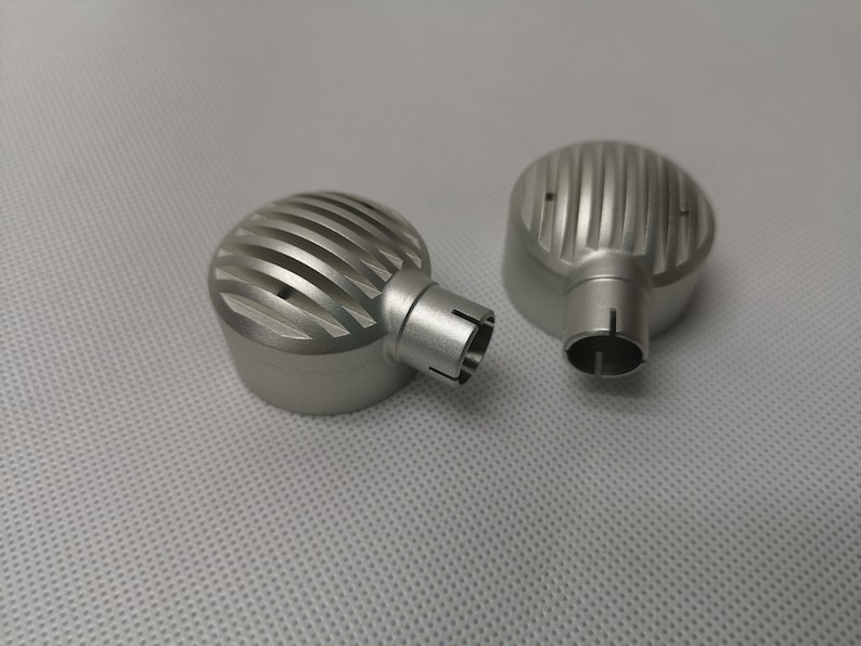 May include: Two silver metal earbud covers with a ridged design. The covers have a small opening on the side.