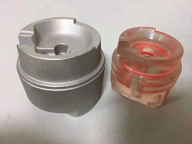 Puede incluir: Dos tapas met&aacute;licas redondas, una plateada y otra transparente con un anillo rojo en el interior. La tapa plateada tiene un peque&ntilde;o agujero en el centro.