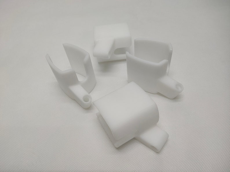 Peut inclure: Quatre pi&egrave;ces en plastique blanc imprim&eacute;es en 3D avec un design en forme de crochet. Les pi&egrave;ces sont con&ccedil;ues pour &ecirc;tre fix&eacute;es &agrave; un objet plus grand.