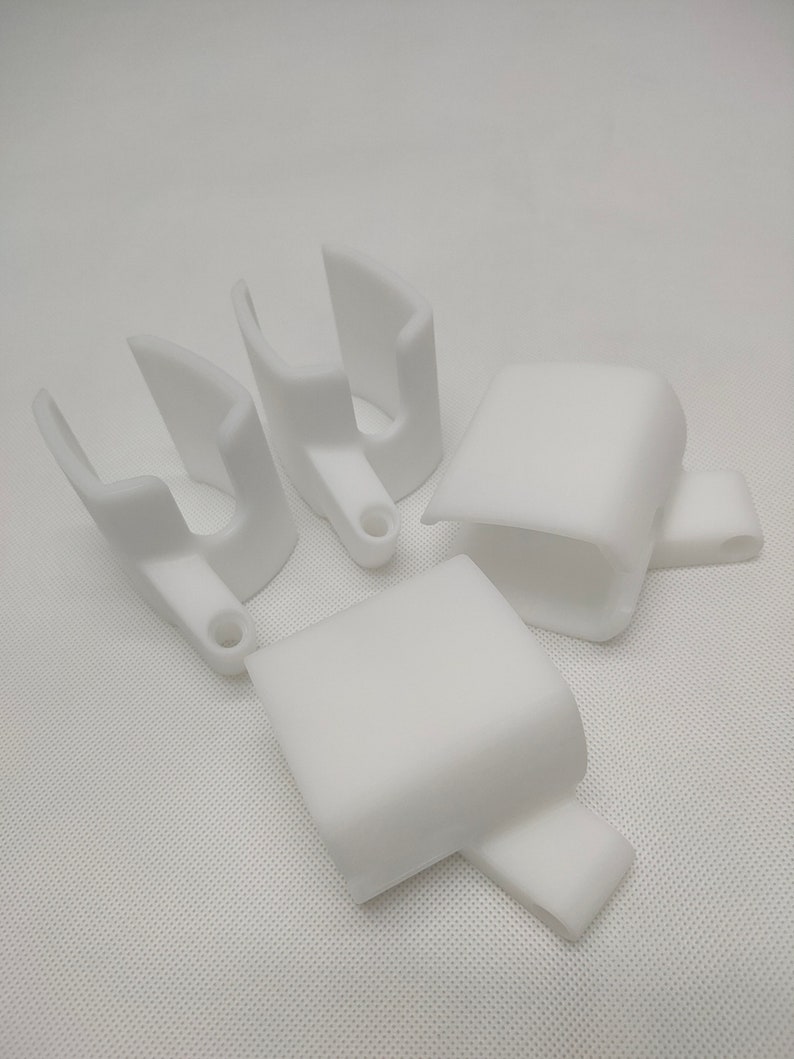 Peut inclure: Quatre supports en plastique blanc imprim&eacute;s en 3D. Deux supports sont en forme de U et deux sont rectangulaires.