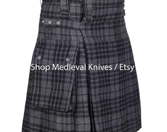 May include: A grey and black plaid kilt with a pleated design. The kilt features a front flap with a pocket, metal buttons, and adjustable straps. The text "Shop Medieval Knives / Etsy" is visible.