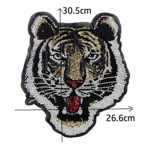 May include: A beaded tiger face applique patch with black, white, gold, and red sequins. The patch measures 12.01 inches wide by 10.24 inches tall.