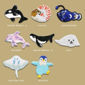 May include: Embroidered patches featuring marine life, including a killer whale, conch, lanternfish, dolphin, seal, electric ray, and penguin. Each patch is a unique design with detailed stitching and vibrant colors, perfect for adding to clothing or accessories.