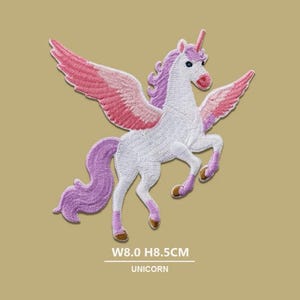 Peut inclure: Écusson brodé d'une licorne blanche avec des ailes roses et rouges, une crinière et une queue violettes et une corne rose. Le patch mesure 8,0 cm de large et 8,5 cm de haut. Le mot "UNICORN" est imprimé en dessous.