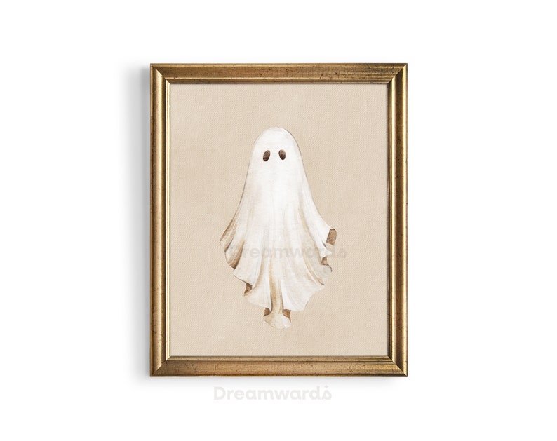 May include: A framed illustration of a white ghost with two black eyes. The frame is gold with a beige mat.