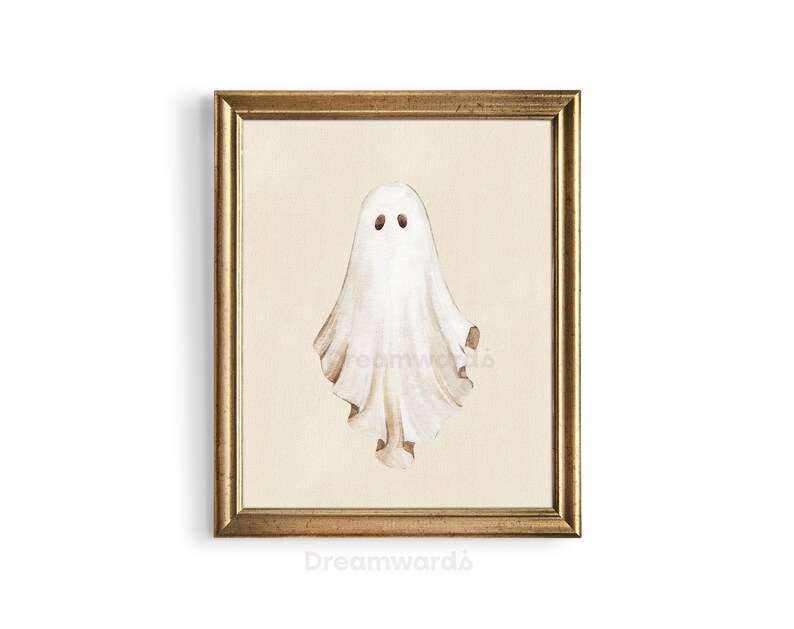 May include: A framed watercolor painting of a white ghost with two black eyes. The ghost is depicted in a simple, whimsical style, with a flowing, translucent form. The background is a light beige color, and the frame is a simple gold color.