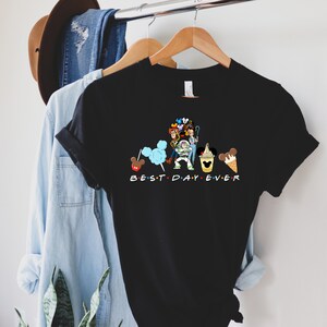 Puede incluir: Camiseta negra con un gr&aacute;fico de personajes de Disney y el texto "BEST DAY EVER".