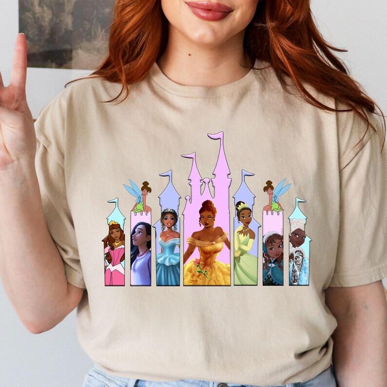 a woman wearing a t - shirt with a picture of princesses on it