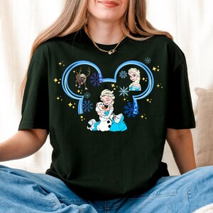 A woman wearing a black t-shirt with a graphic design featuring characters from the Disney movie Frozen.