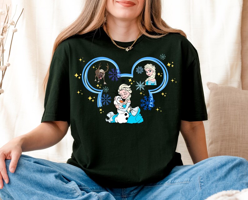 A woman wearing a black t-shirt with a graphic design featuring characters from the Disney movie Frozen.