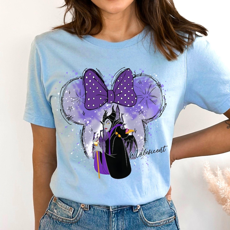 a woman wearing a blue shirt with a minnie mouse on it