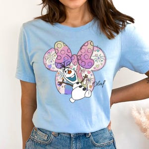 a woman wearing a blue shirt with a cartoon character on it