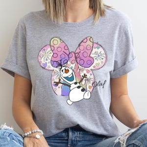 a woman wearing a gray shirt with a snowman on it