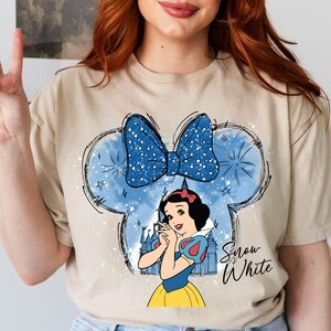 a woman with red hair wearing a t - shirt with snow white on it