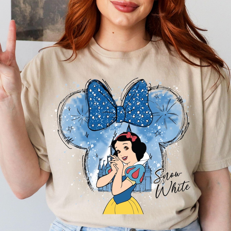 a woman with red hair wearing a t - shirt with snow white on it
