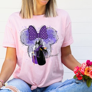 a woman wearing a pink shirt with a minnie mouse on it