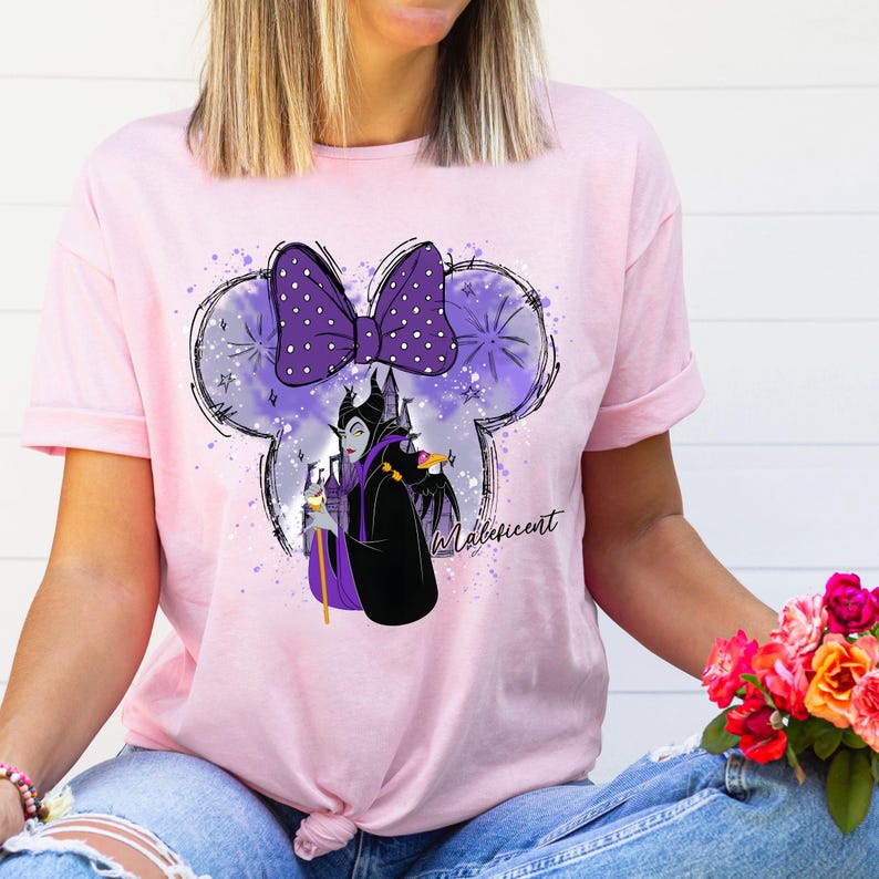 a woman wearing a pink shirt with a minnie mouse on it