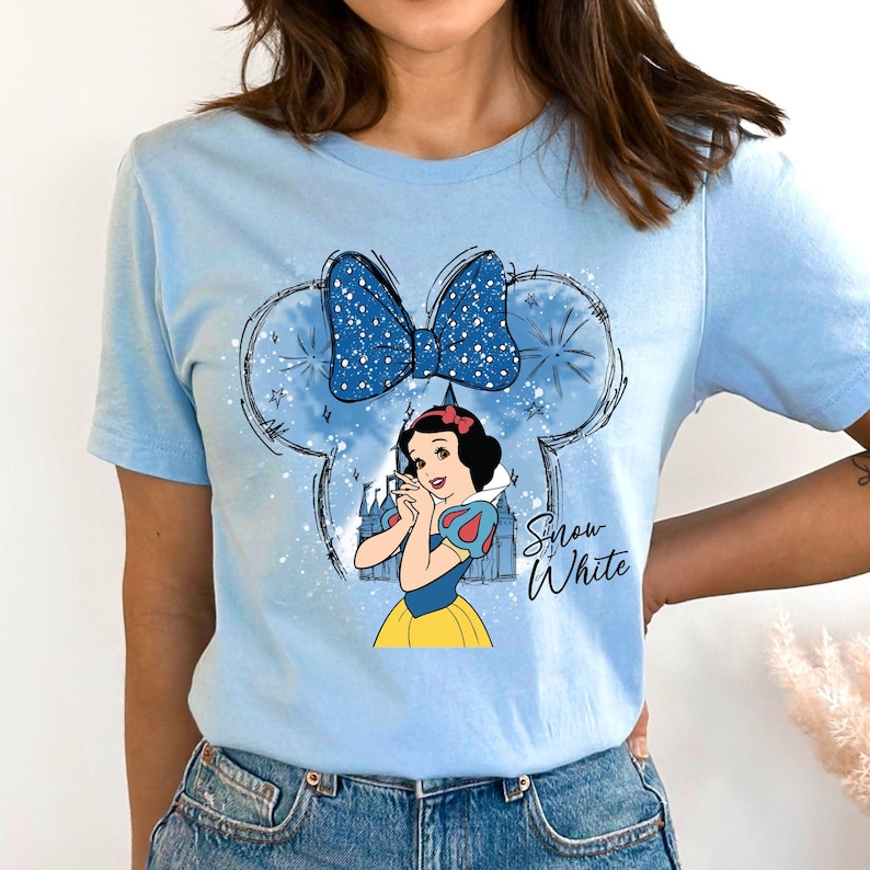 a woman wearing a blue shirt with snow white on it