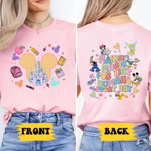 a woman wearing a pink shirt with mickey mouse on it
