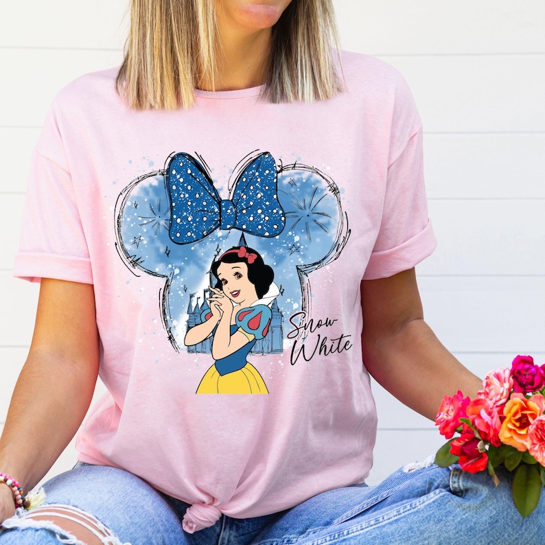 a woman wearing a pink shirt with snow white on it