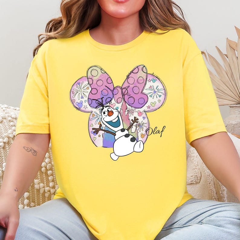 a woman sitting on a couch wearing a yellow shirt