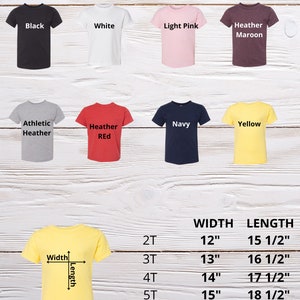 May include: A size chart for toddler t-shirts in various colors, including black, white, light pink, heather maroon, athletic heather, heather red, navy, and yellow. The chart shows the width and length measurements in inches for sizes 2T, 3T, 4T, and 5T.