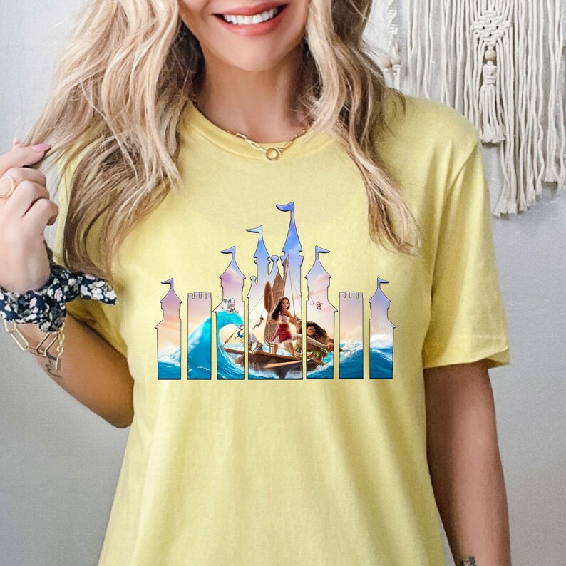 a woman wearing a yellow shirt with a picture of a castle on it