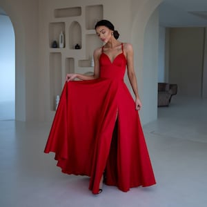 サイドスリット入りのレッドサテンAラインマキシドレス。プロムや結婚式のゲストに最適。縫い付けワイヤーなしカップ付きレッドサテンAラインプロムドレス。