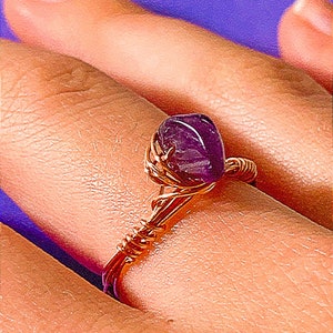 May include: A purple amethyst gemstone wrapped in copper wire to create a ring.
